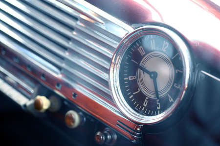 Color shot of a vintage clock on a car's dashboard.