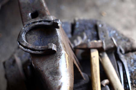 Color shot with a hammer, a horse shoe and an anvil.の写真素材