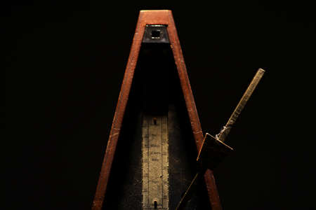 Horizontal shot of a vintage metronome, on a black .の写真素材