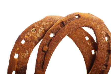 Color shot of two  rusty horse shoes isolated on white.の写真素材