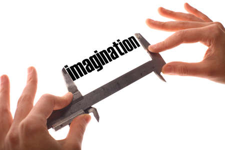 Color horizontal shot of two hands holding a caliper and measuring the word "imagination".の写真素材