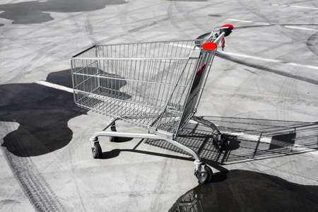 Color image of an abandoned shopping trolley in a parking lot.