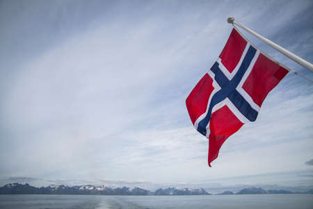 Color image of the Norwegian flag against the sky.の写真素材