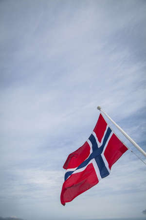 Color image of the Norwegian flag against the sky.の写真素材