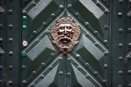 Color image of a very old lion door knocker.