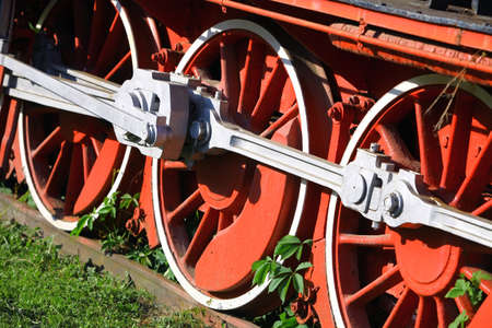 Color image of an abandoned steam locomotive's wheels, with plants growing around them.の写真素材