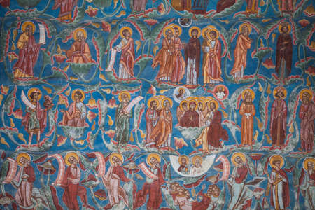 Color image of some very old religious Orthodox paintings on a wall.