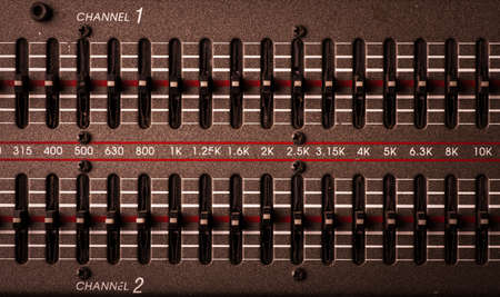 Color image of many buttons on a sound mixer in a recording studio.