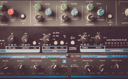 Color image of many buttons on a sound mixer in a recording studio.