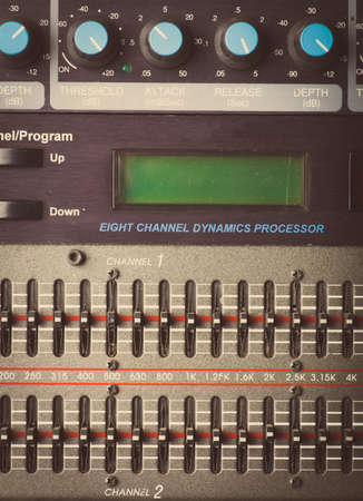 Color image of many buttons on a sound mixer in a recording studio.
