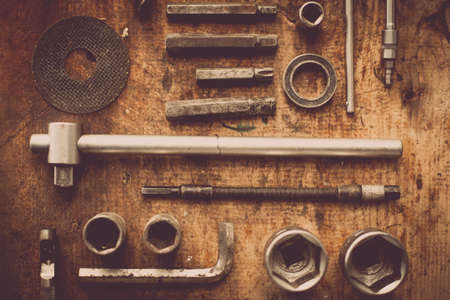 Color image of many tools on a wooden plank.