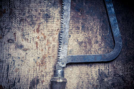 Color image of a hacksaw on a wooden plank.の写真素材