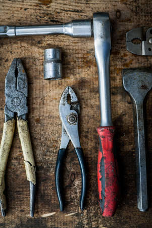 Color image of many tools on a wooden plank.