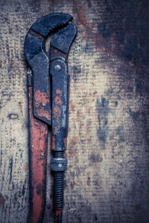 Color image of an adjustable wrench on a wooden plank.