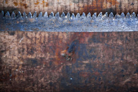 Color image of a hacksaw on a wooden plank.の写真素材