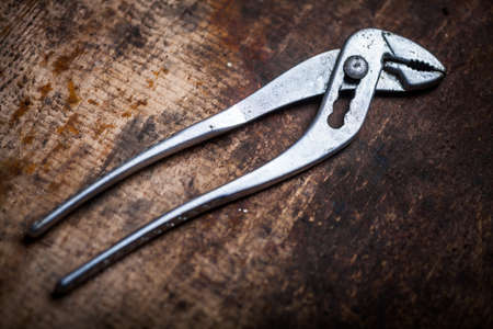 Color image of an adjustable pliers on a wooden plank.の写真素材