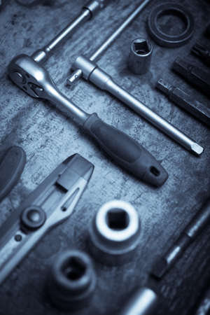Color image of many tools on a wooden plank.