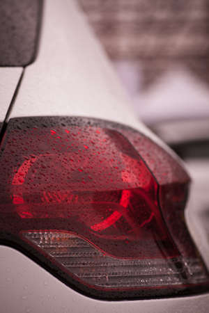 Detail on the rear light of a car on a rainy day.の写真素材