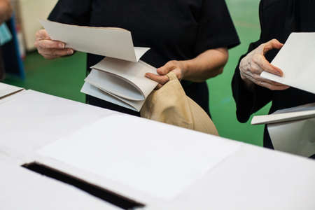 A person prepares to cast a ballot at a polling station during voting.の写真素材