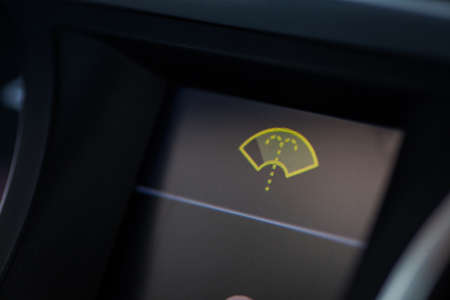 Close-up shot of a car's dashboard, with the wind screen washer icon lit.の写真素材
