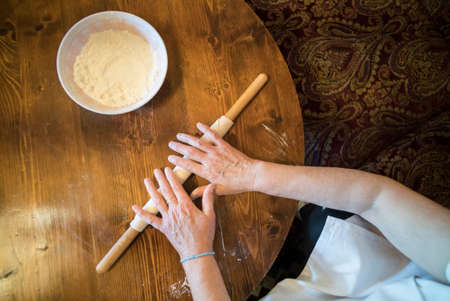 A woman preparing a Tatar pie, on a table.