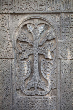 Close up shot of a cross carved in a stone.