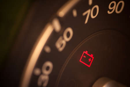 Close up shot of a car's dashboard with the battery icon lit.の写真素材