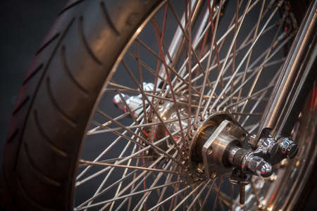 Close up shot of a motorcycle wheel, with spokes.