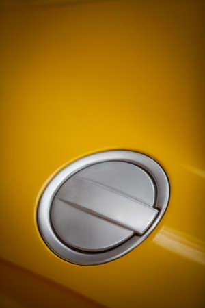 Close up shot of a car's fuel tank lid, closed.