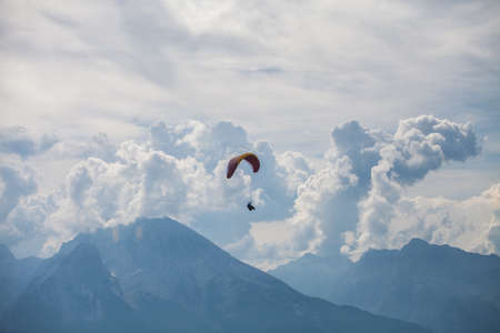 Color image of a paraglider flying, with clouds in the background.の写真素材