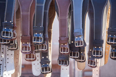 Color image of some leather belts on display.