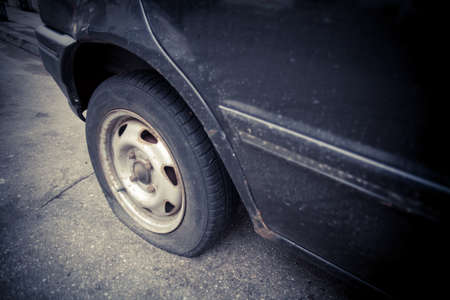 Close up shot of a car with a flat tire.の写真素材