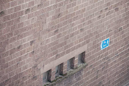 Arrow sign on a brick wall, pointing east.