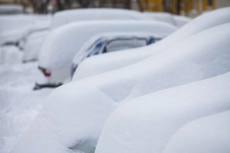 A line of parked cars covered in snow.の写真素材