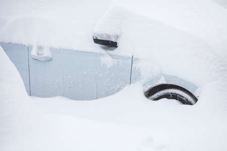 Color image of a parked car, under heavy snow.の写真素材