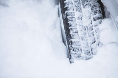 Close up shot of a car's winter tire, in snow.の写真素材