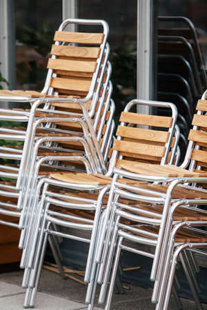 Color image of a stack of wooden chairs on a terrace.の写真素材