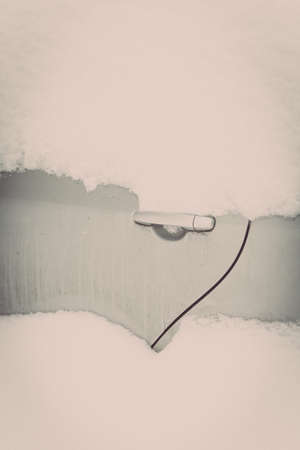 Color image of a parked car door handle, under heavy snow.の写真素材