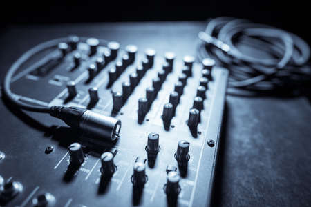 Close up shot of a mixer desk with many buttons and cables.の写真素材