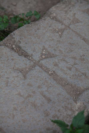 Close up shot of a cross carved in a stone.
