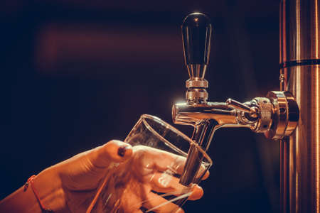 Image of a waiter pouring draught beer into a glass, in a pub or restaurant.の写真素材