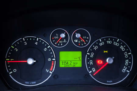 Close up shot of a car's illuminated dashboard, at night.