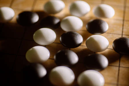 Close up shot of a Go board game, with black and white stones.の写真素材