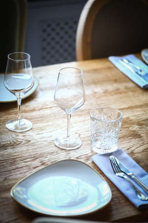 Close up shot of a wine glass on a table, near an empty plate.の写真素材