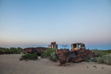 Color image of some wrecked ships, on the former banks of the Aral sea in Moynaq, Uzbekistan.の写真素材