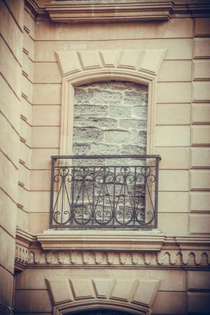 Color image of a bricked up window and a balcony.