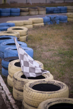 Race flag, yellow and blue tires on the floor of race course.の写真素材