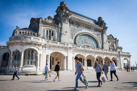 Constanta, Romania - May 26, 2018: People walk in front of the famous abandoned casino in Constanta, Romania, Black Sea shore.のeditorial素材