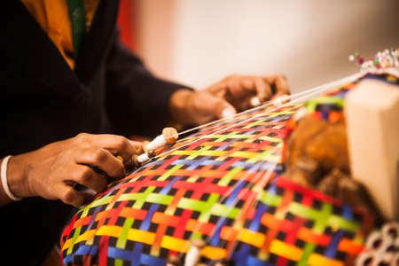 Close up image of a woman's hands weaving some cloth.