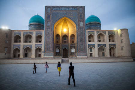 June 3, 2017 - Bukhara, Uzbekistan: Tourists walk in front of the Kalyan minaret and mosque, Bukhara, Uzbekistan.のeditorial素材